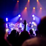 A lively concert scene with enthusiastic audience enjoying vibrant stage lights.